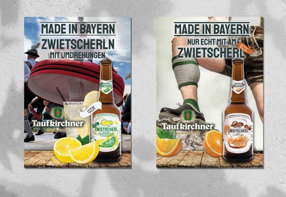 Das Bild zeigt 2 Poster mit bayerischen Motiven, die das Getränk Zwietscherl bewerben.